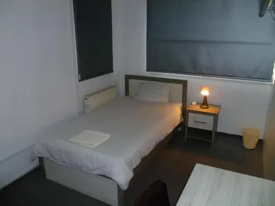 a small bedroom with a bed and a candle on a table at Datacom Guest House in Nicosia