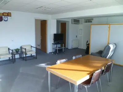 a room with a table and chairs and a tv at Datacom Guest House in Nicosia