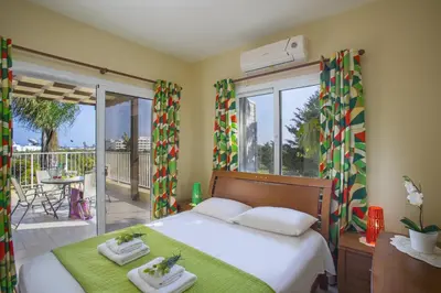 a bedroom with a bed and a balcony at Ayia Napa Tropical Beach Villa in Ayia Napa