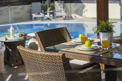 a table with chairs and a table with food on it at Ayia Napa Tropical Beach Villa in Ayia Napa