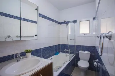 a bathroom with a sink and a toilet and a bath tub at Ayia Napa Tropical Beach Villa in Ayia Napa