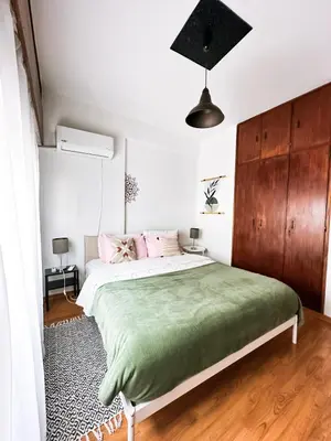 a bedroom with a large bed with a green blanket at Comfortable Engomi Apartment in Yukarı Lakatamya