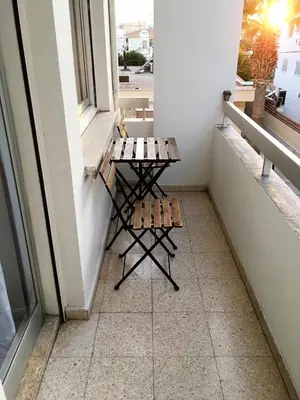 a bench on a balcony with a table at Comfortable Engomi Apartment in Yukarı Lakatamya