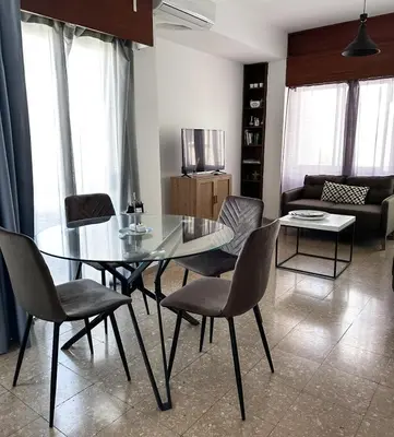 a dining room with a glass table and chairs at Comfortable Engomi Apartment in Yukarı Lakatamya