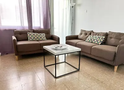 a living room with two couches and a coffee table at Comfortable Engomi Apartment in Yukarı Lakatamya