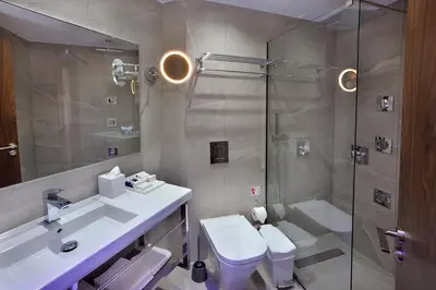 a bathroom with a shower and a sink and a toilet at Okeanos Beach Boutique Hotel in Ayia Napa