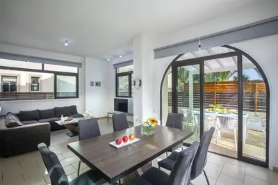 a living room with a table and chairs at Villa Mylos 8 in Protaras
