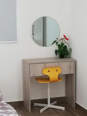 a wooden dressing table with a mirror and a yellow chair at Chicos Studios in Ayia Napa