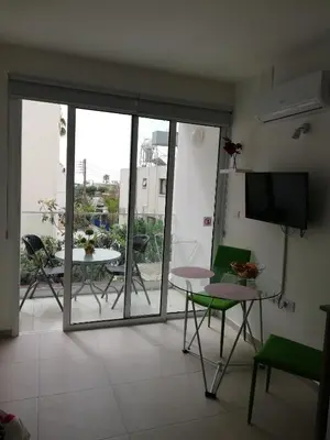a living room with a sliding glass door with a table and chairs at Chicos Studios in Ayia Napa