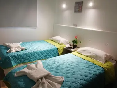 two beds with towels on them in a room at Chicos Studios in Ayia Napa