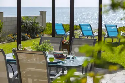 a table and chairs with a view of the ocean at Meneou Beachfront Villa in Meneou