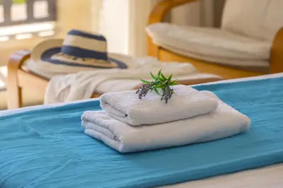a pile of towels on a table with a hat at Meneou Beachfront Villa in Meneou