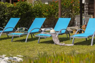 a group of blue chairs on the grass at Meneou Beachfront Villa in Meneou