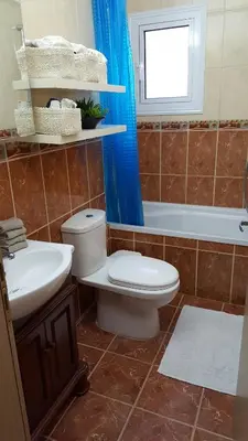 a bathroom with a toilet and a tub and a sink at Million flowers in Protaras