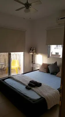 a bedroom with a large bed with a ceiling fan at Million flowers in Protaras