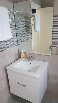 a bathroom with a white sink and a mirror at Manoli Apartments in Ayia Napa