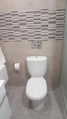 a bathroom with a toilet and a sign on the wall at Manoli Apartments in Ayia Napa
