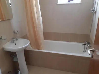a bathroom with a sink and a bath tub at Vasilas Holiday Apartment #1 in Larnaka