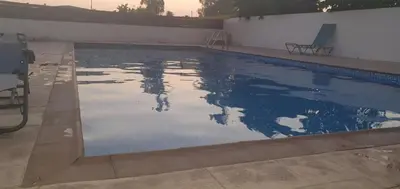 a swimming pool with a reflection in the water at Vasilas Holiday Apartment #1 in Larnaka
