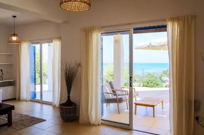 a living room with sliding glass doors with a view of the ocean at Phaedrus Living: Seaside Luxury Villa Anafi in Paralimni