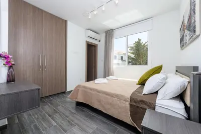a bedroom with a large bed and a window at Green Bay Villa #13 in Protaras