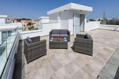 a patio with two chairs and a table on a balcony at Green Bay Villa #13 in Protaras