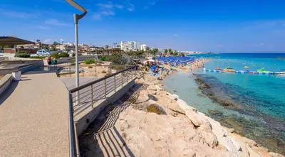 a beach with a bunch of people in the water at Green Bay Villa #13 in Protaras