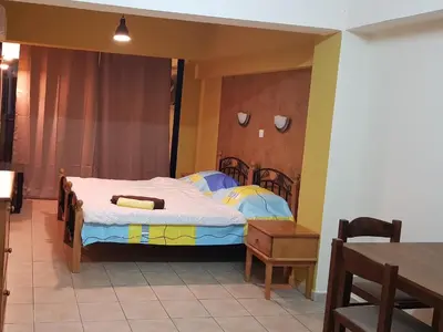 a bedroom with a bed and a wooden headboard at Pomelo Apartments in Ayia Napa