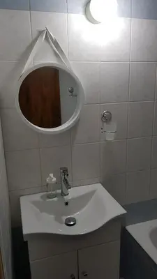 a bathroom with a white sink and a mirror at Pomelo Apartments in Ayia Napa