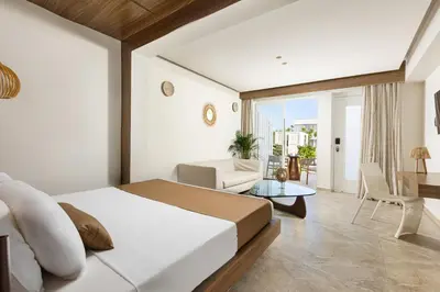 a bedroom with a bed and a living room at So White Beach Resort in Ayia Napa