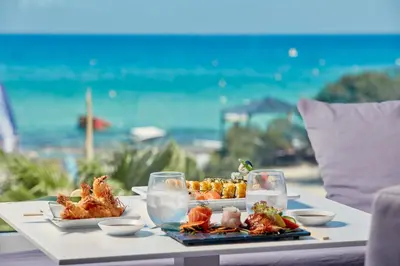 a table with food on it with a view of the ocean at So White Beach Resort in Ayia Napa