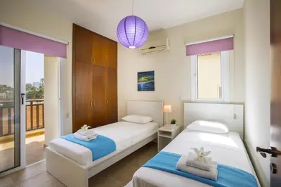 two beds in a room with a balcony at Protaras Galleria Sunset Villa in Paralimni