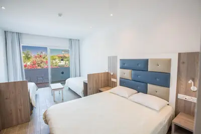 a hotel room with a bed and a window at Stratovarius Nissi Rooms in Ayia Napa