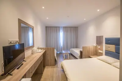 a hotel room with a bed and a flat screen tv at Stratovarius Nissi Rooms in Ayia Napa