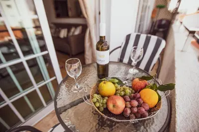 a bowl of fruit on a table with a bottle of wine at Beach Haven in Larnaka