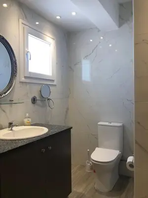 a bathroom with a toilet and a sink and a window at Katerina in Ayia Napa
