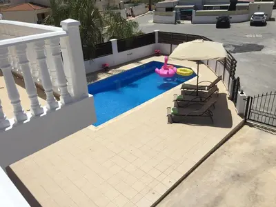 a swimming pool with a pink ball and an umbrella at Katerina in Ayia Napa