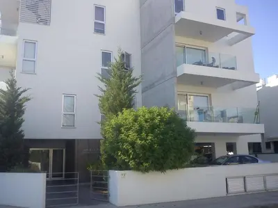 a tall white building with a car parked in front of it at Achillion Gardens, near UNIC By 'Flats Nicosia' in Nicosia