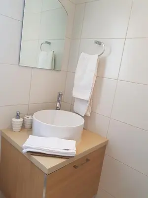 a bathroom with a sink and a mirror at Achillion Gardens, near UNIC By 'Flats Nicosia' in Nicosia