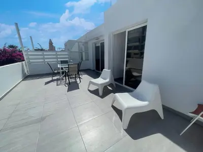 a balcony with a table and chairs on a roof at Christina Apartment in Protaras