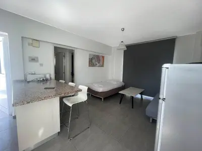 a room with a kitchen and a room with a bed at Christina Apartment in Protaras
