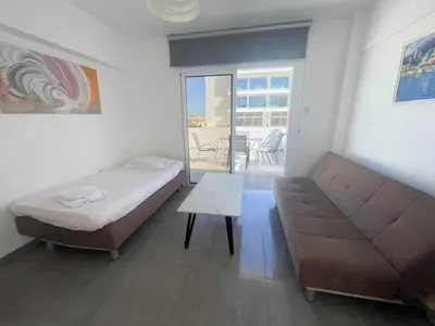 a bedroom with a bed and a couch and a table at Christina Apartment in Protaras