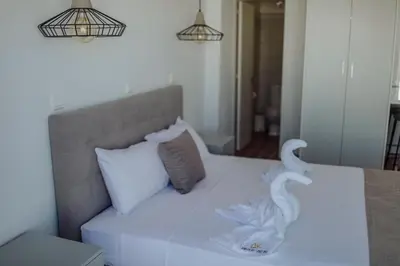 a white bed with two swans on it at River View Boutique Apts in Ayia Napa
