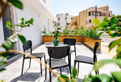 a patio with chairs and a table with a vase on it at River View Boutique Apts in Ayia Napa