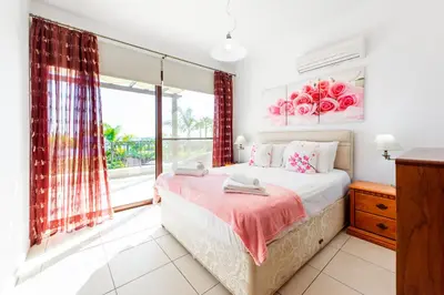 a bedroom with a bed and a window at Sea Front Oceanus H2 by Ezoria Villas in Ayia Napa