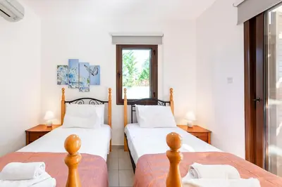 a bedroom with two beds and a window at Villa Poseidon by Ezoria Villas in Ayia Napa