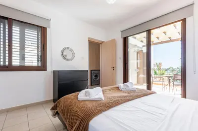 a bedroom with a bed with two towels on it at Villa Poseidon by Ezoria Villas in Ayia Napa