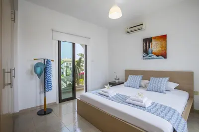 a bedroom with a large bed with blue and white pillows at Konnos Blue in Protaras