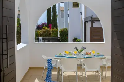 a dining room with a table and chairs and a mirror at Konnos Blue in Protaras