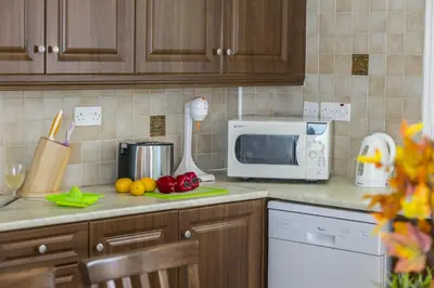 a kitchen with a counter top with a microwave and vegetables at Konnos Blue in Protaras